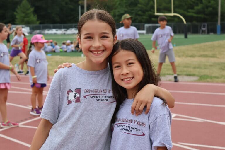 Two SFS athletes smiling on the track