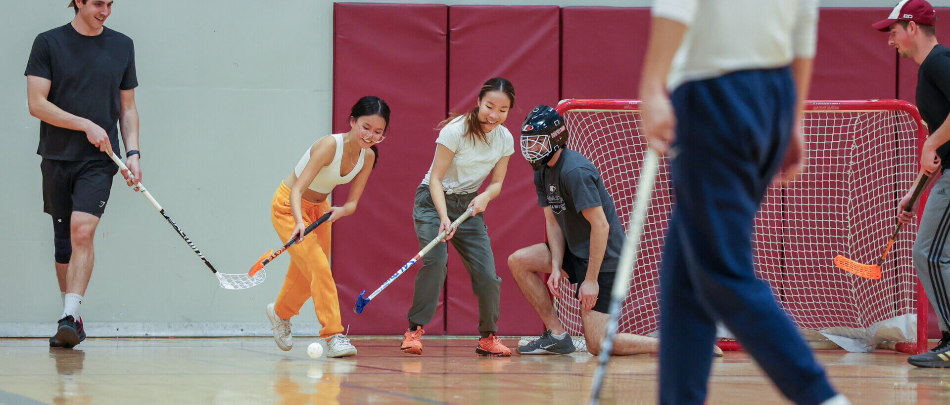 A group of students enjoy a game of floorball
